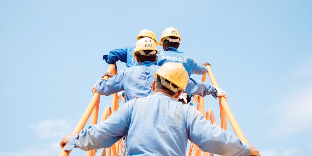 Workers with yellow helmets climbing a stairway to heaven