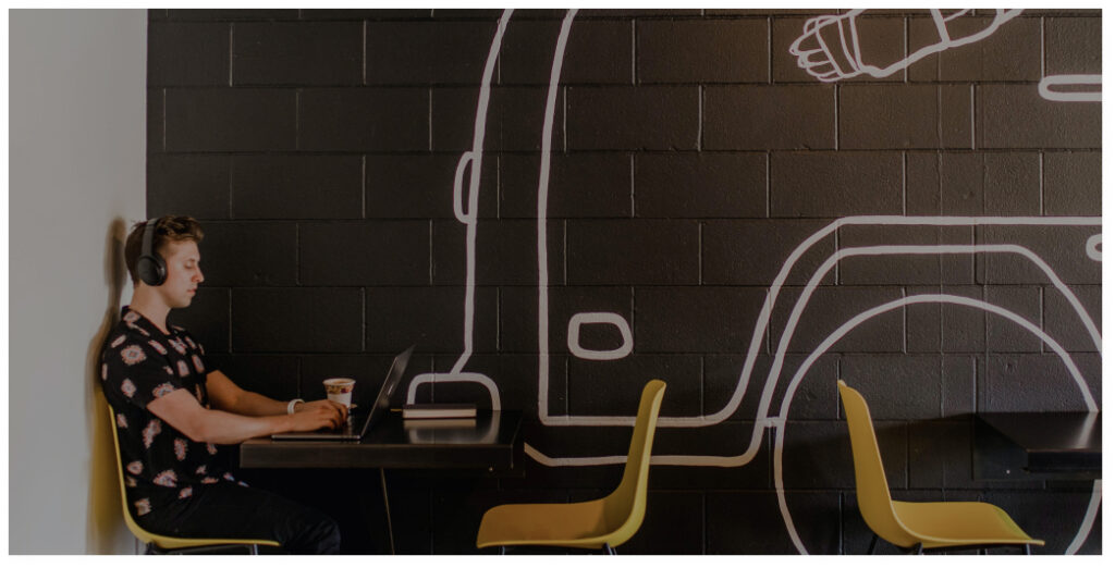 man working on a laptop in a cafe